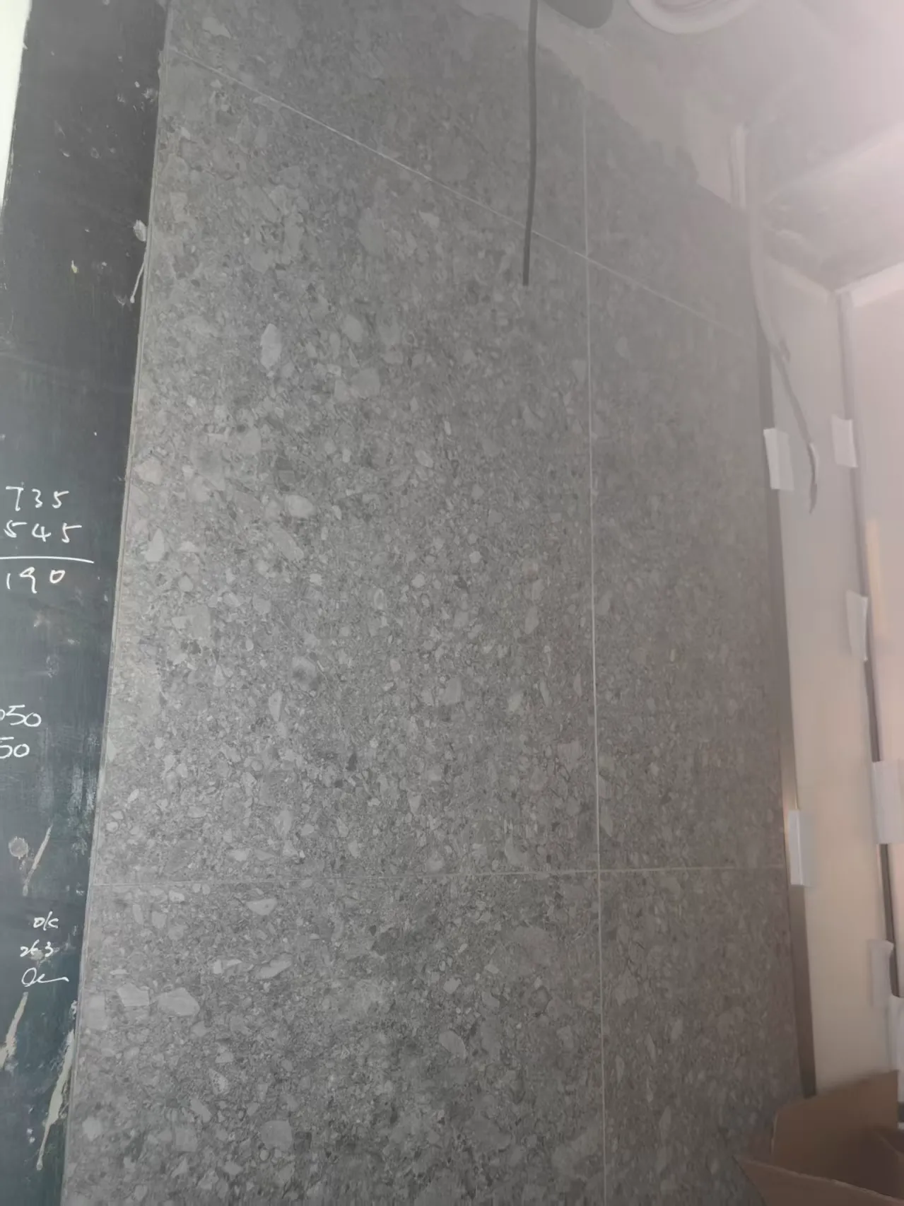 750×750 mm grey terrazzo-look matte ceramic tiles installed on an interior wall at the Sha Tin residential project.